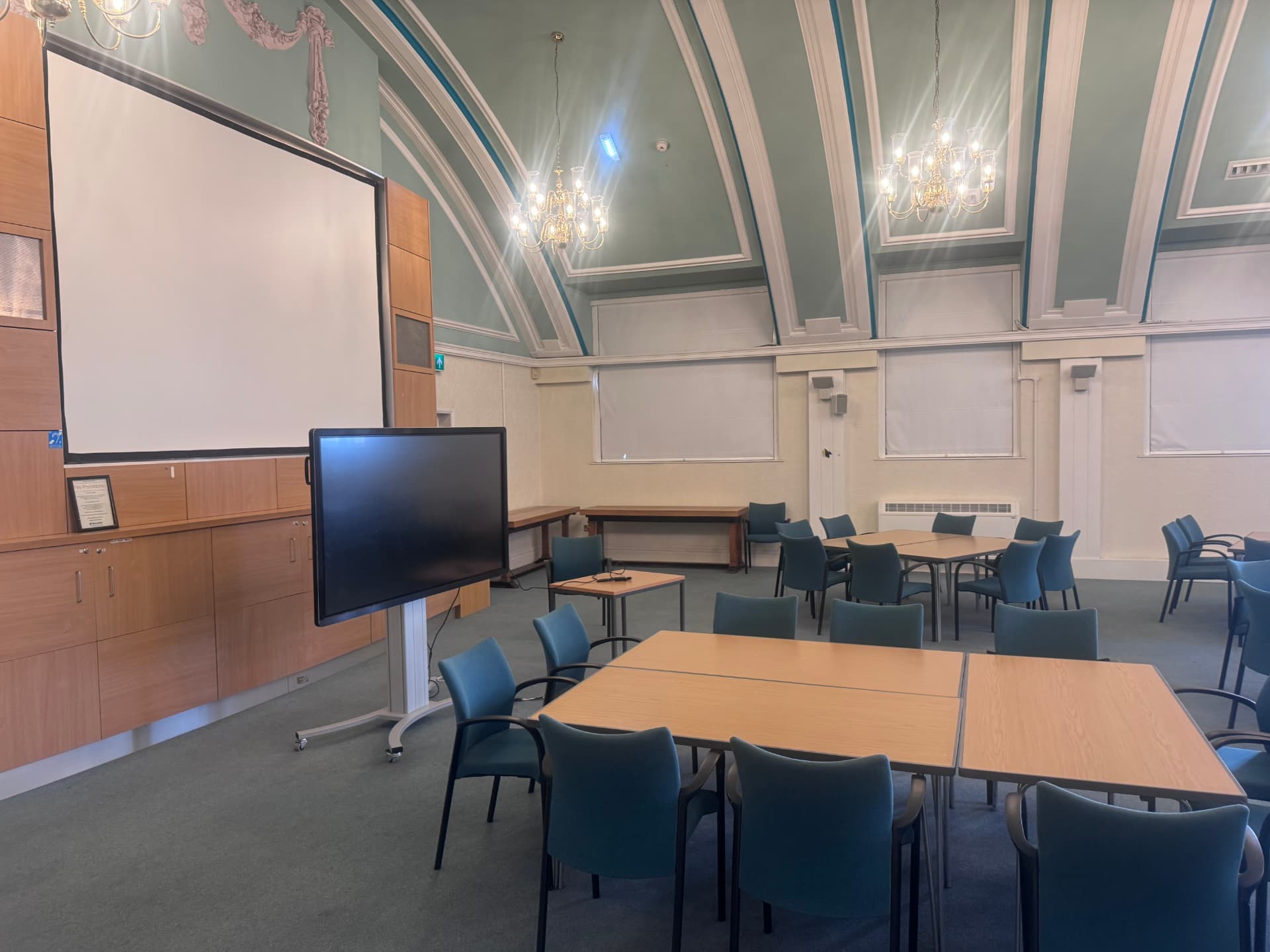 Hyde Town Hall meeting space with a large screen and projector used for quizzes, talks and sing-along sessions